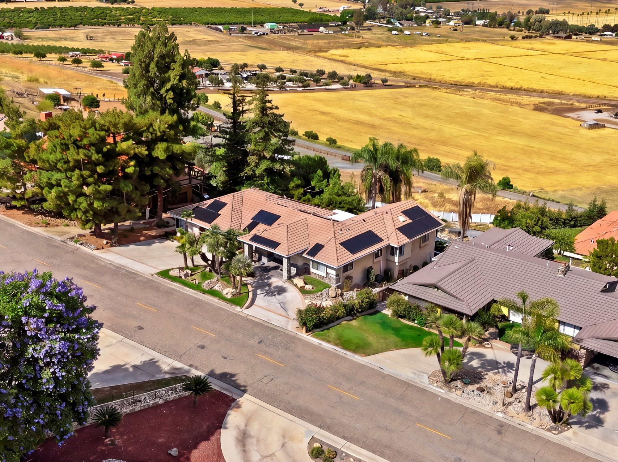 Aerial drone real estate photography of a hillside estate above farmland in Porterville, California