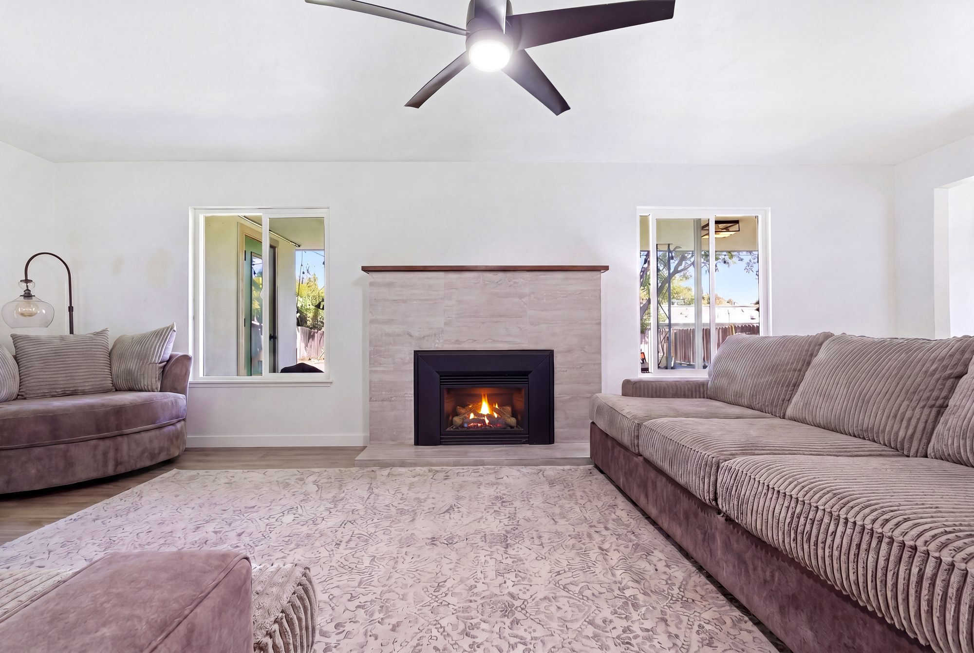 Real estate photography of a living room with a lit fireplace in Fresno, California