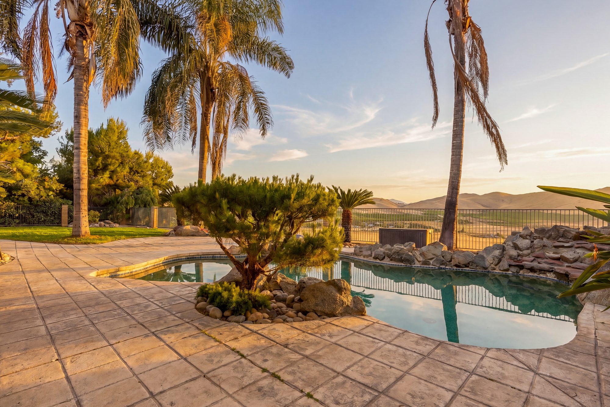 Golden hour real estate photography of a hillside pool and foothill view in Porterville, California