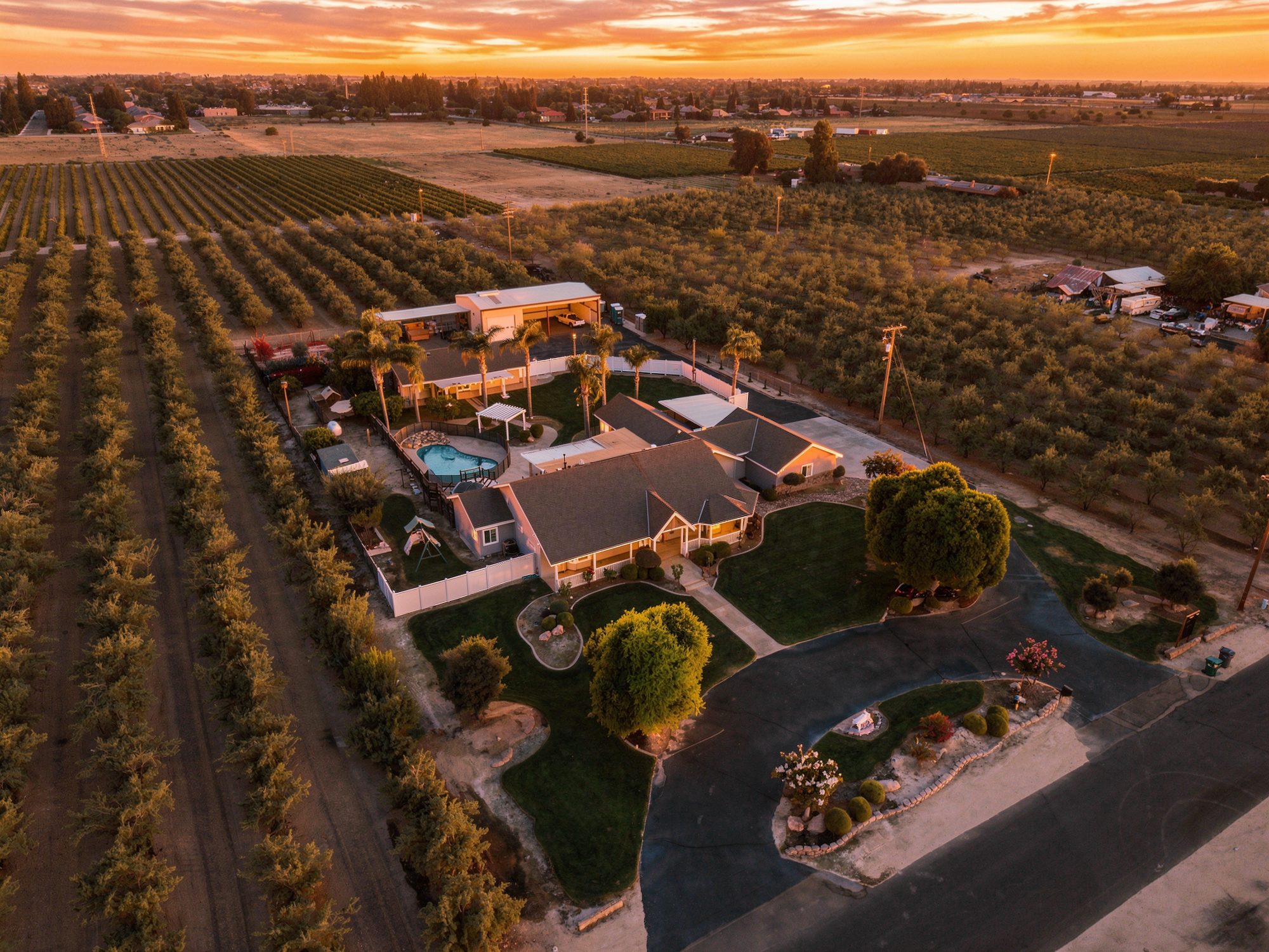 Aerial drone real estate photography of an orchard estate at dusk in Selma, California